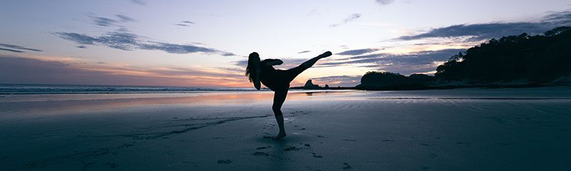 a person practicing martial arts on the beach