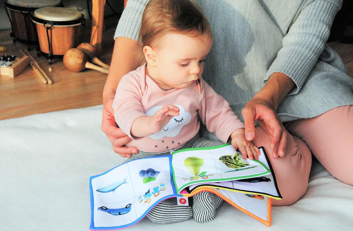 a baby being read to on a parent's lap
