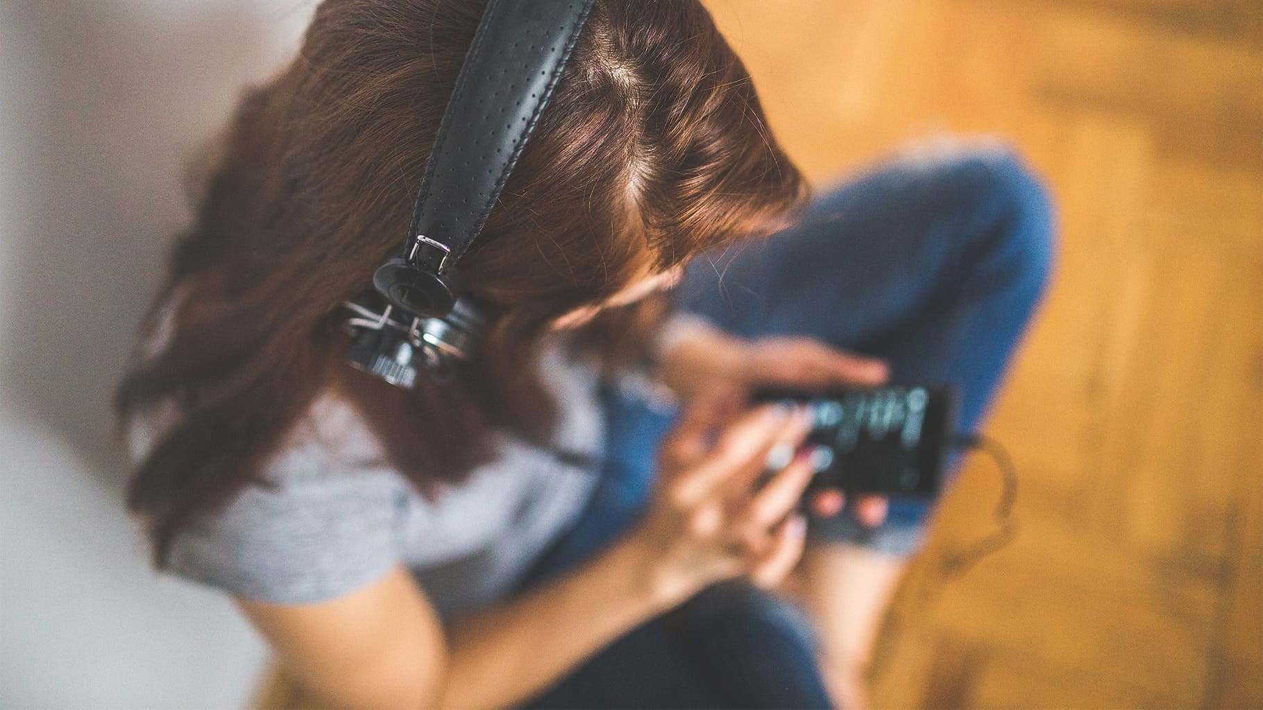a woman with headphones listening to music on her smartphone