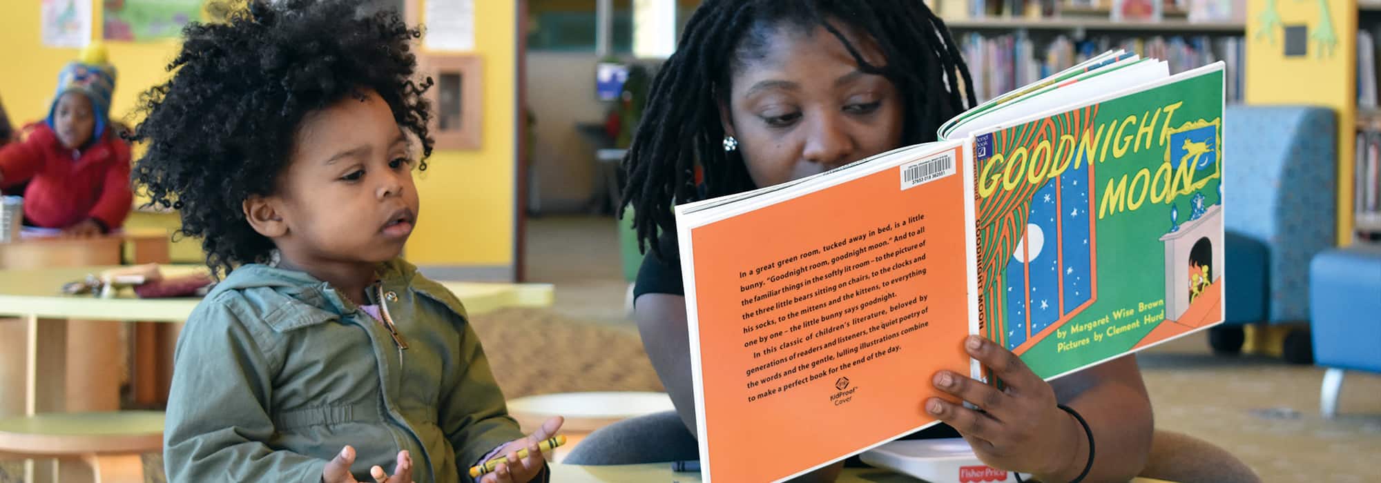 a mother reading to her child at the library