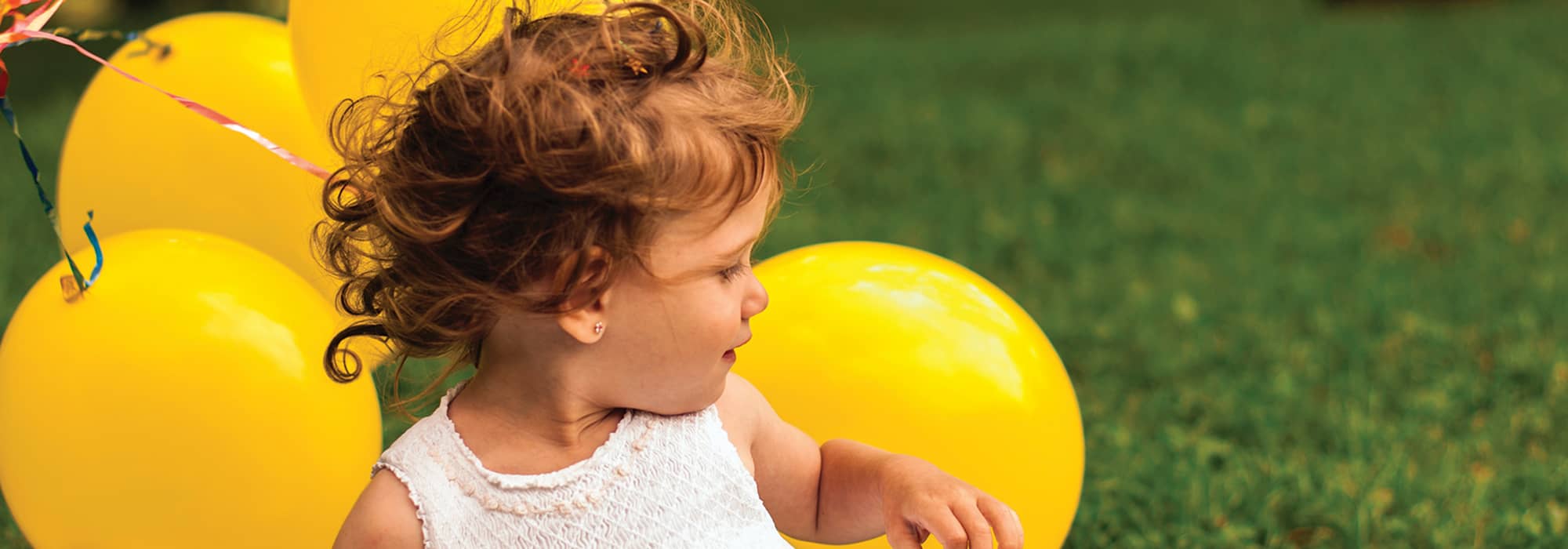 a girl with yellow balloons