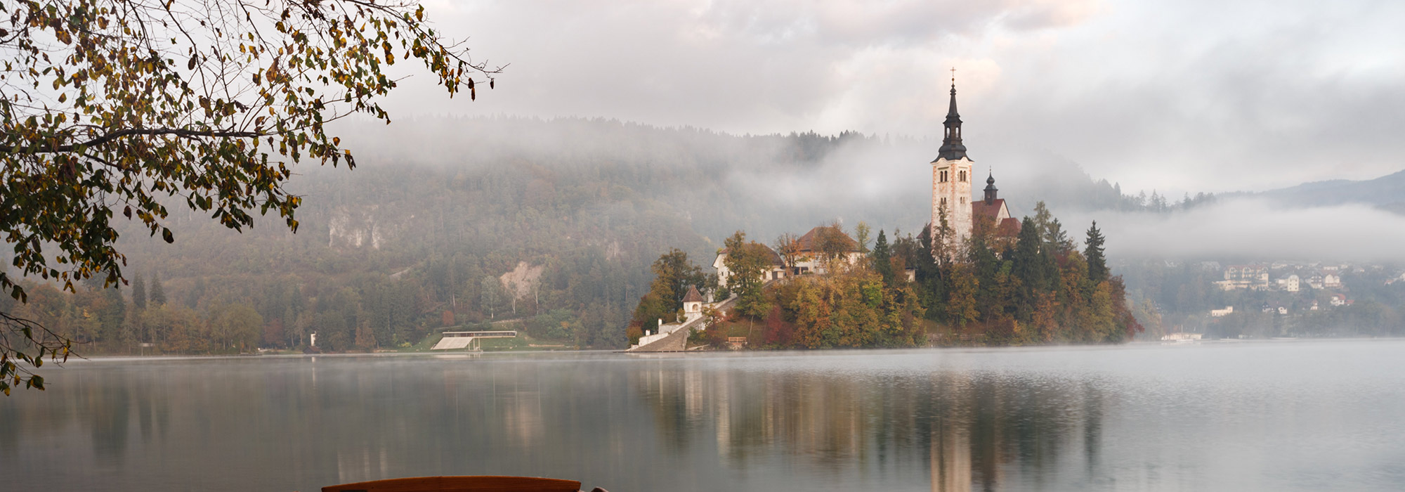 castle viewed across a lake with low fog