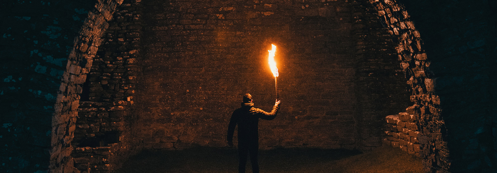 a man holding a torch in an underground tunnel