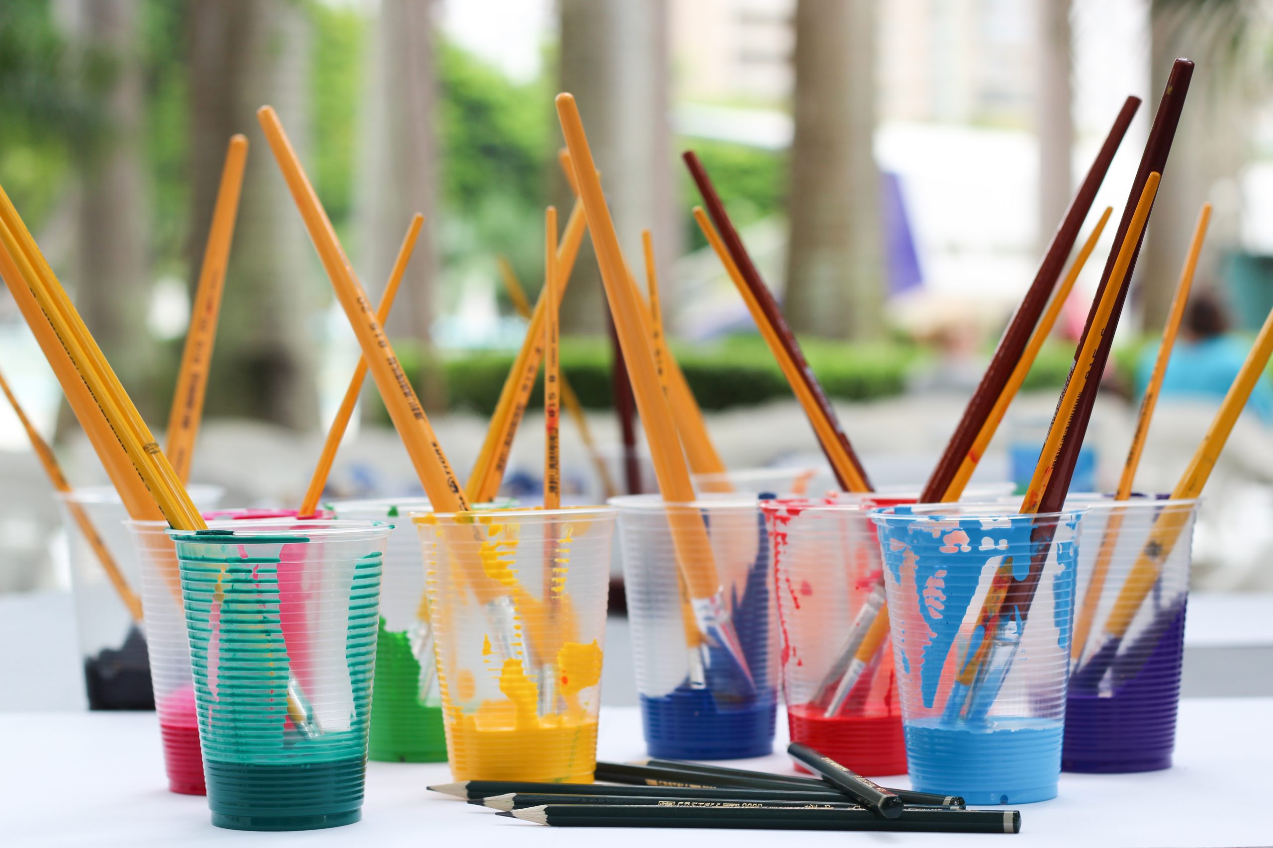 paint and brushes in plastic cups