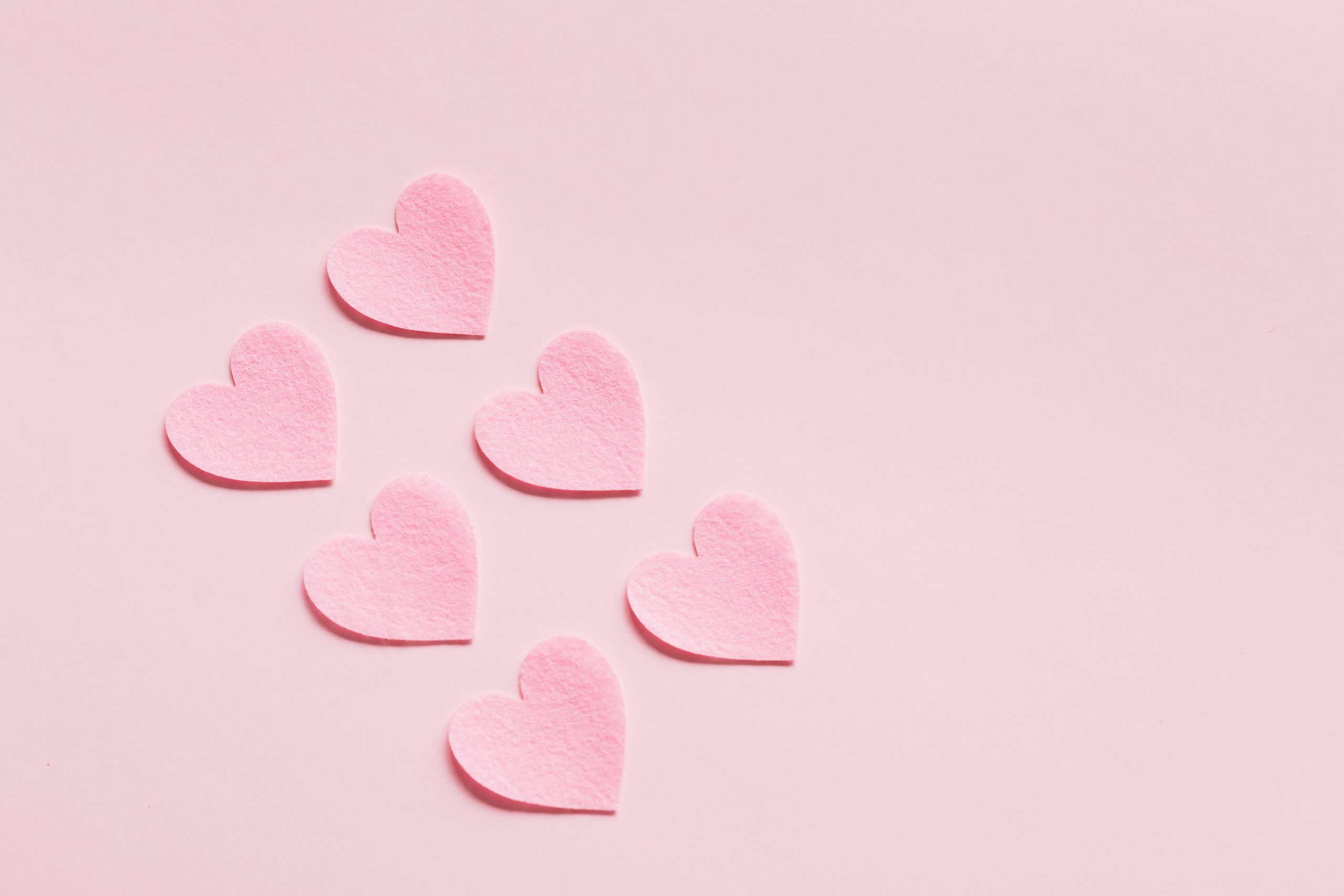 six little pink hearts on a pink background