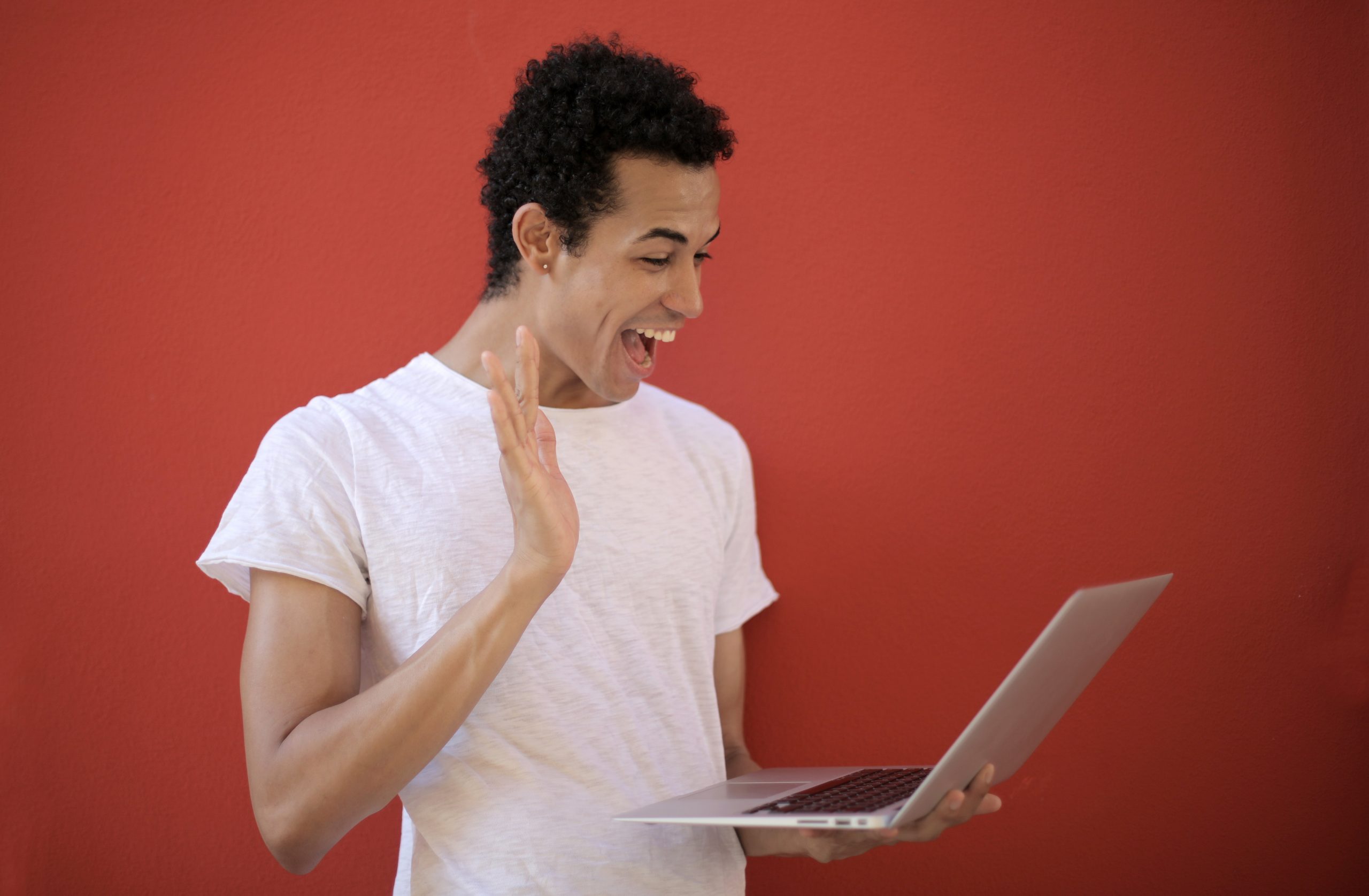 person waving excitedly to a computer screen