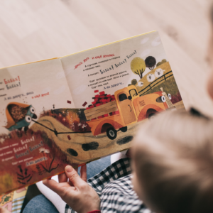 kid reading book with adult