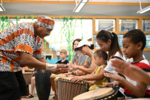 man teaching kids to drum