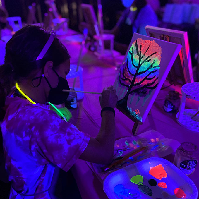 girl painting with glow-in-the-dark paints